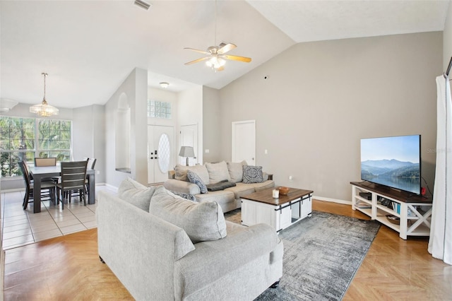 living area with high vaulted ceiling, baseboards, and a ceiling fan