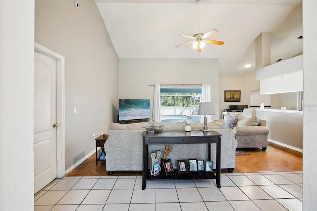 living area featuring lofted ceiling, baseboards, and ceiling fan