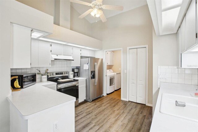 kitchen featuring under cabinet range hood, backsplash, appliances with stainless steel finishes, and light countertops