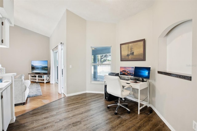 office space featuring vaulted ceiling, wood finished floors, and baseboards