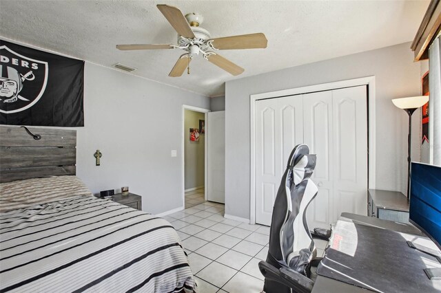 bedroom with visible vents, light tile patterned floors, a closet, baseboards, and ceiling fan
