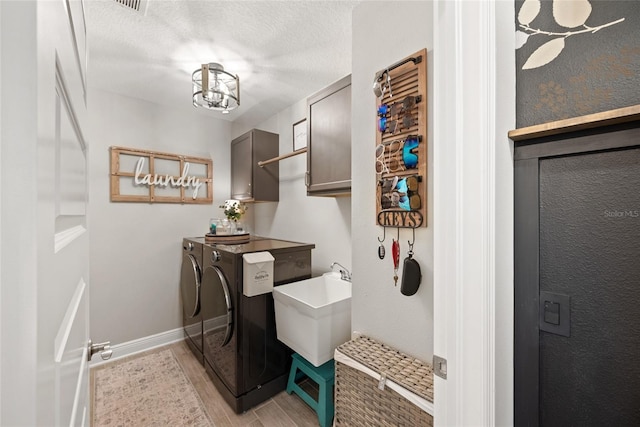 4108 Mellon Dr, Odessa, FL 33556 - washroom featuring light wood-style floors, a textured ceiling, washing machine and dryer, a sink, and cabinet space