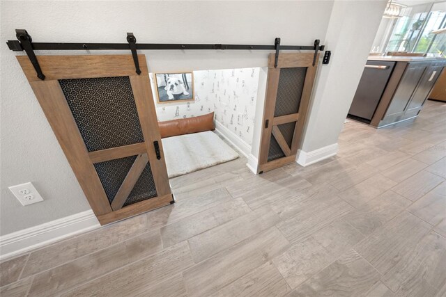 4108 Mellon Dr, Odessa, FL 33556 - basement featuring a barn door, light wood-style floors, and baseboards