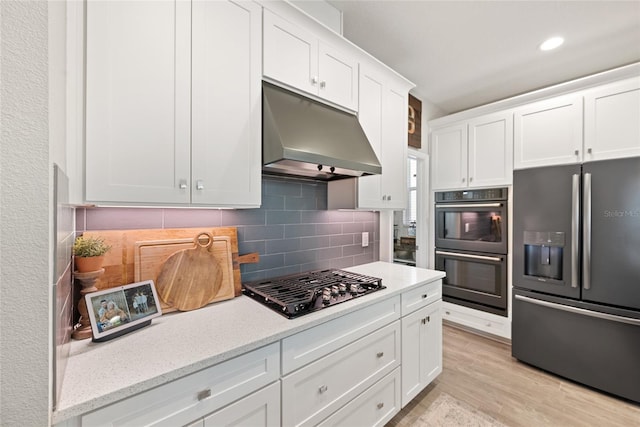 4108 Mellon Dr, Odessa, FL 33556 - kitchen with dobule oven black, stainless steel fridge with ice dispenser, white cabinets, gas cooktop, and under cabinet range hood