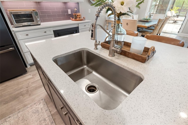 4108 Mellon Dr, Odessa, FL 33556 - kitchen with a toaster, white cabinetry, backsplash, fridge, and a sink