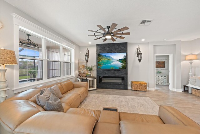 4108 Mellon Dr, Odessa, FL 33556 - living area featuring a ceiling fan, a large fireplace, visible vents, wood finished floors, and baseboards