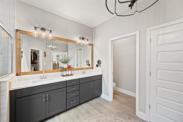 4108 Mellon Dr, Odessa, FL 33556 - full bath featuring toilet, wood finished floors, an inviting chandelier, and a sink