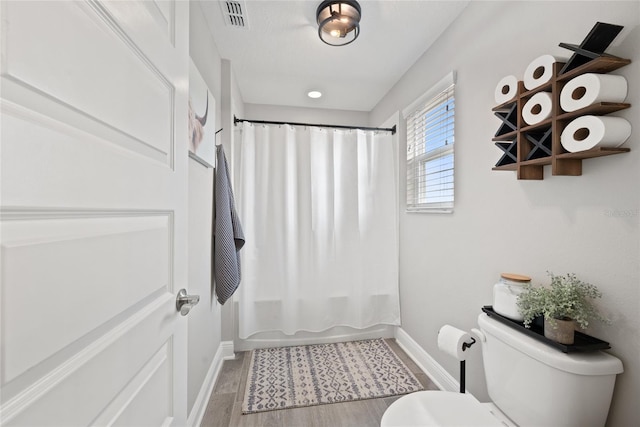 4108 Mellon Dr, Odessa, FL 33556 - bathroom featuring visible vents, toilet, shower / bath combo, wood finished floors, and baseboards