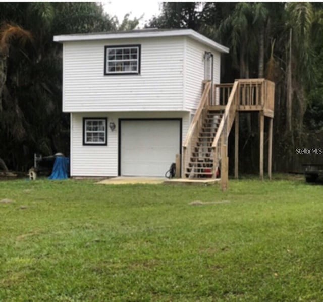22129 Carson Dr, Land O Lakes, FL 34639 - back of property featuring an attached garage, a yard, and stairs