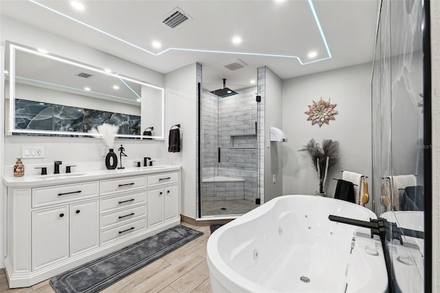 506 Spring Tree Ct, Tarpon Springs, FL 34689 - bathroom featuring a stall shower, a tub with jets, wood finished floors, double vanity, and recessed lighting