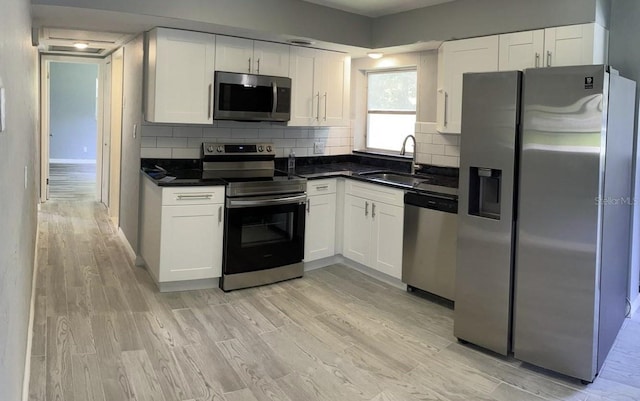 4301 15th Ave N, Saint Petersburg, FL 33713 - kitchen with a sink, appliances with stainless steel finishes, white cabinets, and dark countertops