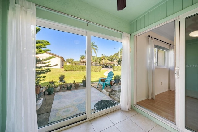 doorway to outside featuring tile patterned flooring and ceiling fan