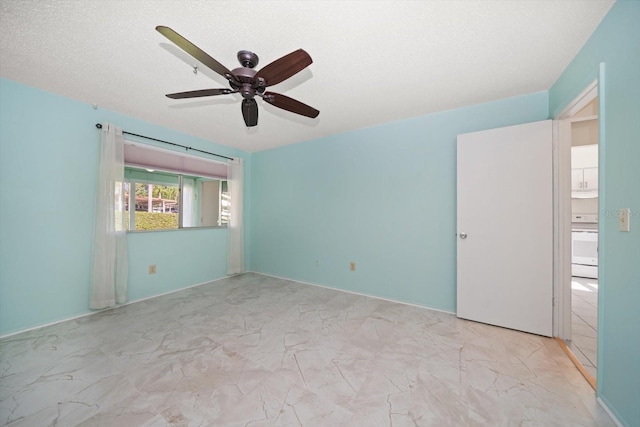 spare room with marble finish floor and ceiling fan
