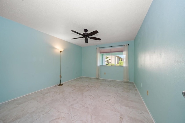 spare room featuring ceiling fan, a textured ceiling, baseboards, and marble finish floor