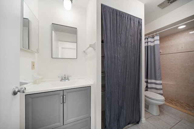 full bath featuring vanity, toilet, visible vents, and tiled shower