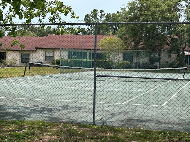 view of tennis court featuring fence