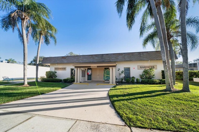 ranch-style house with stucco siding, driveway, and a front yard