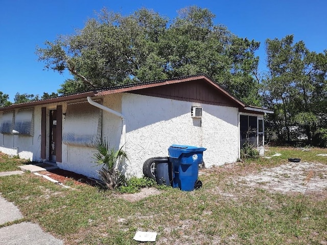 9355 Pinero St, Spring Hill, FL 34608 - view of side of home with stucco siding and an AC wall unit