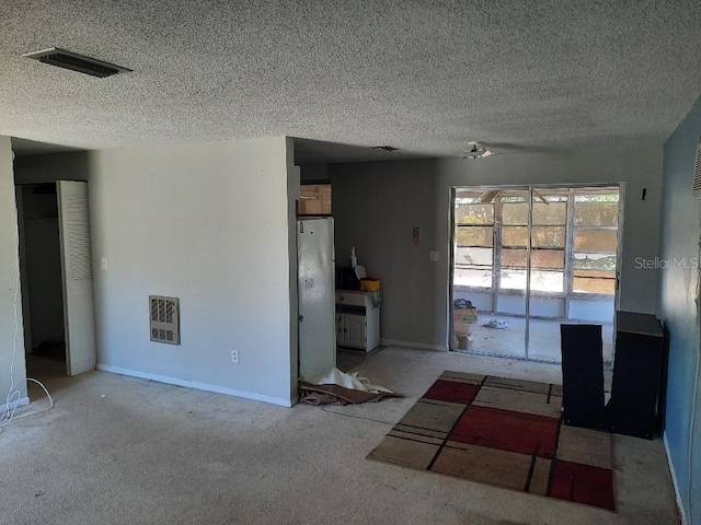 9355 Pinero St, Spring Hill, FL 34608 - unfurnished living room with a textured ceiling, baseboards, carpet, and visible vents