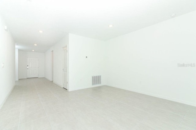 spare room featuring recessed lighting, visible vents, and baseboards