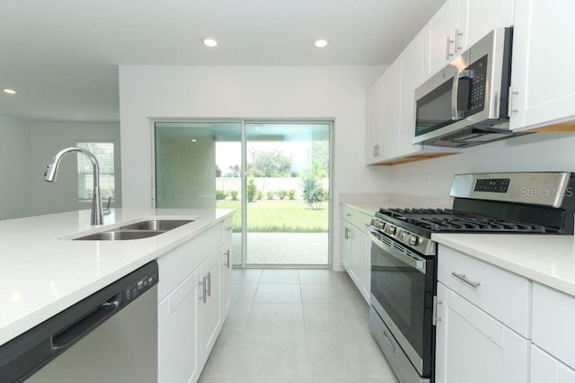kitchen with light countertops, appliances with stainless steel finishes, a sink, and recessed lighting