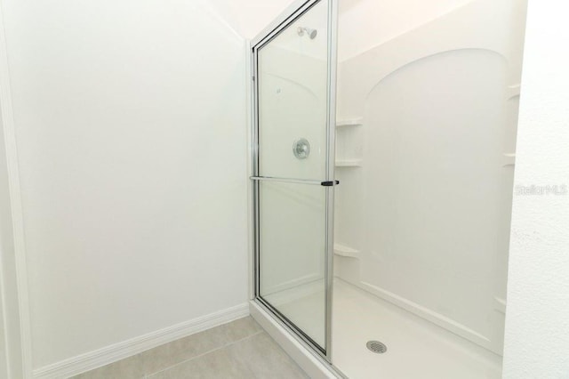 full bath featuring baseboards, a shower stall, and tile patterned flooring