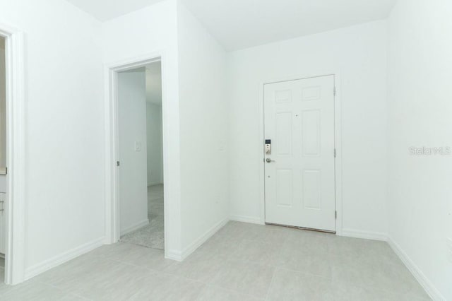 foyer featuring light tile patterned floors and baseboards