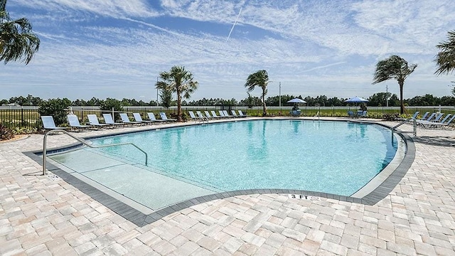 pool with a patio and fence