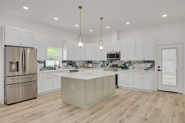 kitchen featuring a center island, backsplash, appliances with stainless steel finishes, and light countertops