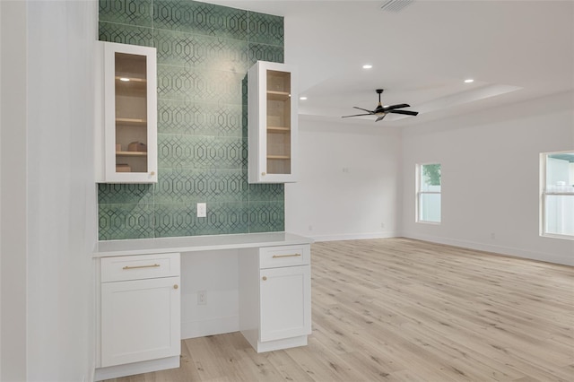 kitchen featuring glass insert cabinets, a ceiling fan, backsplash, light countertops, and white cabinets
