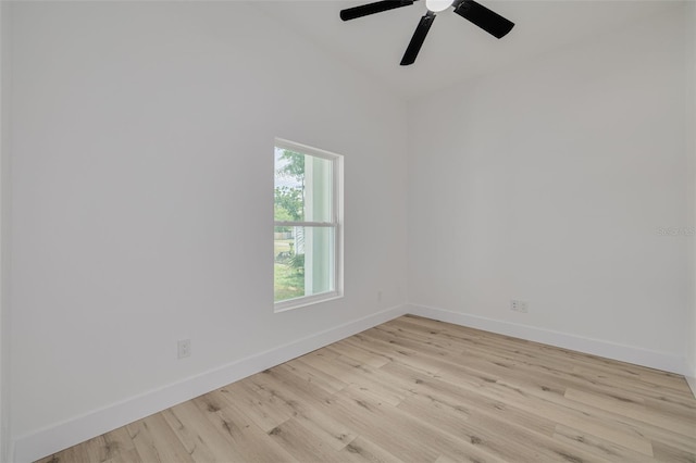 empty room featuring lofted ceiling, ceiling fan, light wood-type flooring, and baseboards