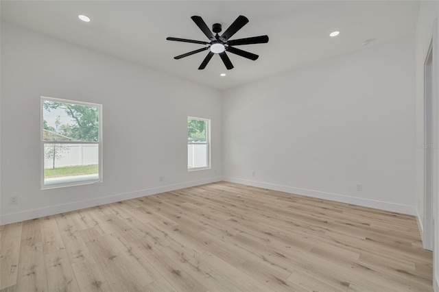 empty room with baseboards, light wood-type flooring, and a healthy amount of sunlight