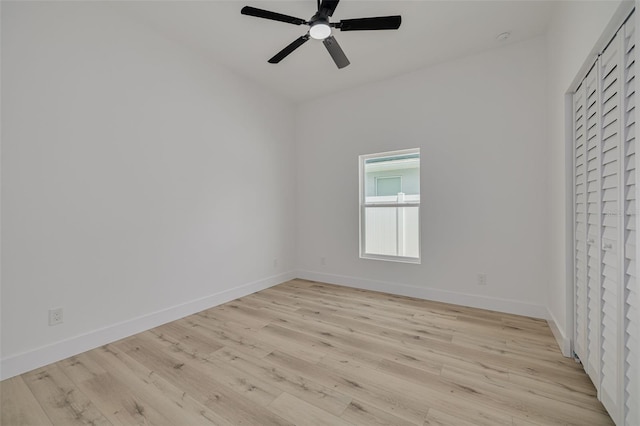 spare room with ceiling fan, baseboards, and light wood-type flooring