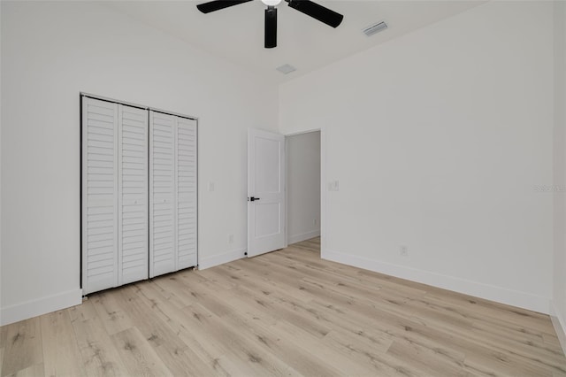 unfurnished bedroom with visible vents, a closet, baseboards, light wood finished floors, and a ceiling fan