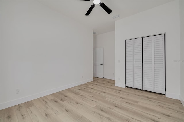 unfurnished bedroom featuring a closet, ceiling fan, visible vents, light wood-style flooring, and baseboards