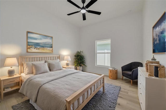 bedroom with baseboards, light wood-type flooring, and a ceiling fan
