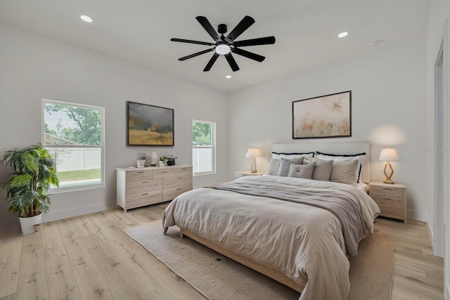bedroom featuring light wood-type flooring, baseboards, and multiple windows