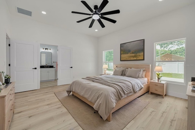 bedroom featuring light wood finished floors, visible vents, and multiple windows