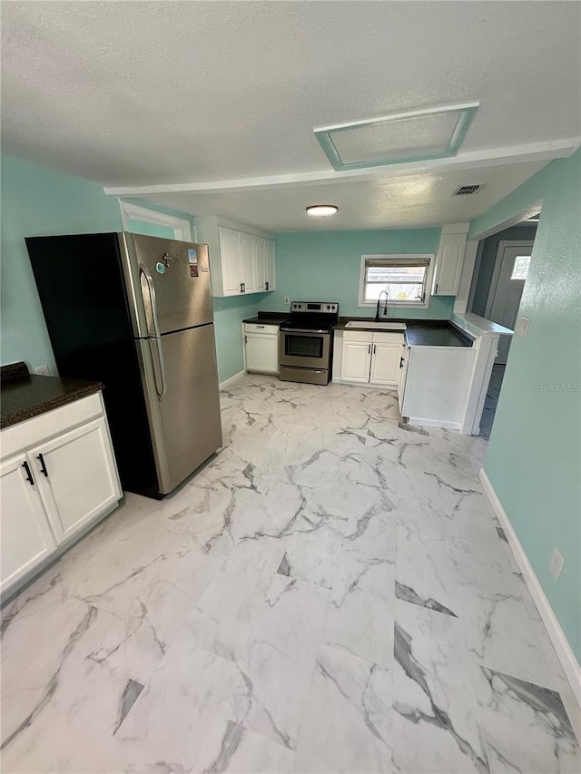 1318 W Broad St, Tampa, FL 33604 - kitchen with a sink, visible vents, dark countertops, a textured ceiling, and appliances with stainless steel finishes
