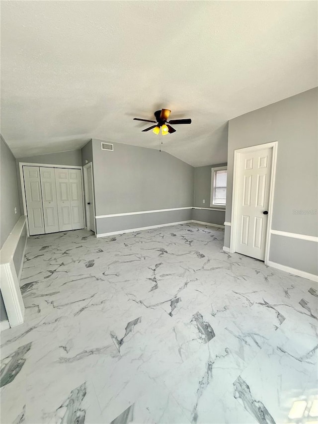 1318 W Broad St, Tampa, FL 33604 - empty room with a textured ceiling, ceiling fan, vaulted ceiling, and baseboards