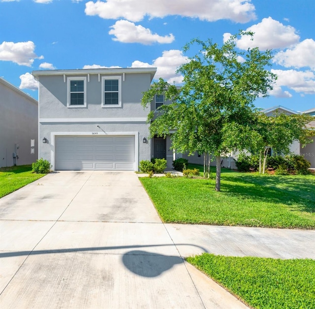 view of front of home featuring concrete driveway, stucco siding, a garage, and a front lawn