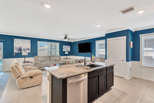 kitchen with ceiling fan, dishwasher, a sink, and a wainscoted wall