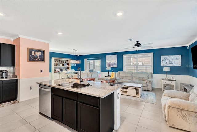 kitchen featuring stainless steel dishwasher, light tile patterned floors, ornamental molding, a sink, and open floor plan