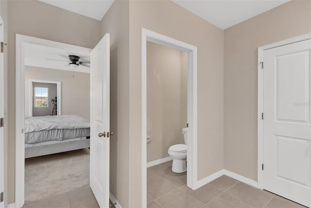ensuite bathroom with ceiling fan, ensuite bathroom, toilet, tile patterned floors, and baseboards