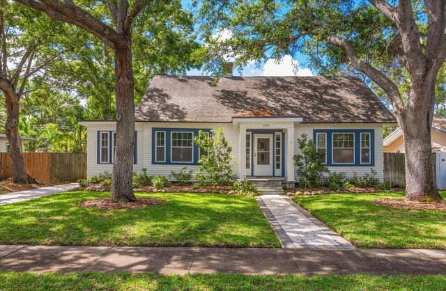 1905 Mckinley St, Clearwater, FL 33765 - view of front of property featuring roof with shingles, a front yard, and fence