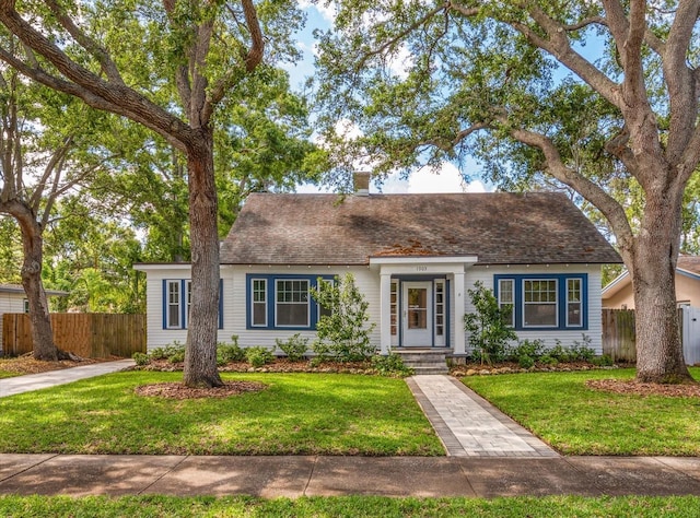 1905 Mckinley St, Clearwater, FL 33765 - view of front facade with a chimney, a front lawn, and fence