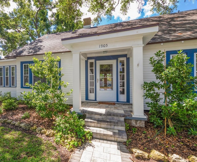 1905 Mckinley St, Clearwater, FL 33765 - property entrance with a shingled roof, a chimney, and covered porch