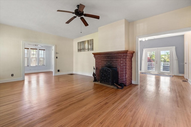1905 Mckinley St, Clearwater, FL 33765 - unfurnished living room with plenty of natural light, ceiling fan, a brick fireplace, and light wood-type flooring