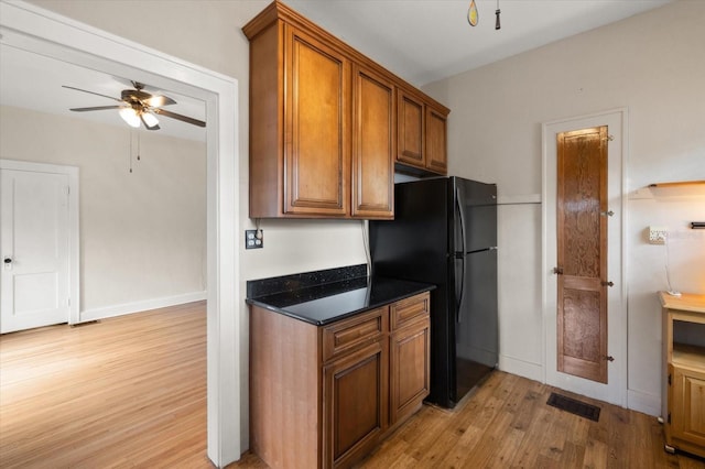 1905 Mckinley St, Clearwater, FL 33765 - kitchen with light wood finished floors, visible vents, a ceiling fan, freestanding refrigerator, and brown cabinetry
