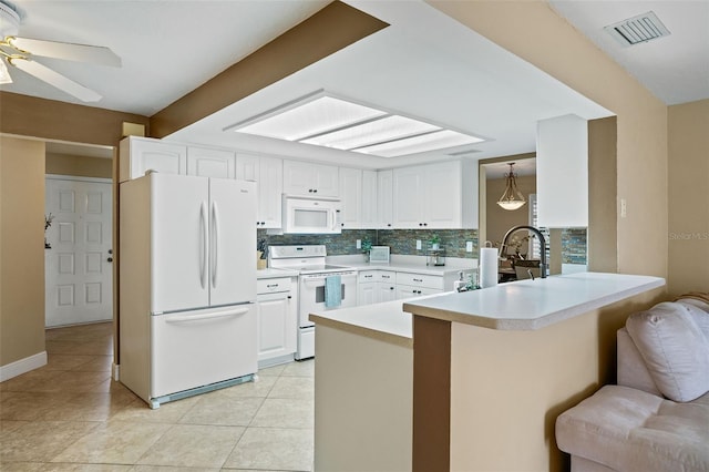 8763 Matthew St, Seminole, FL 33772 - kitchen with white appliances, a peninsula, white cabinets, visible vents, and a sink